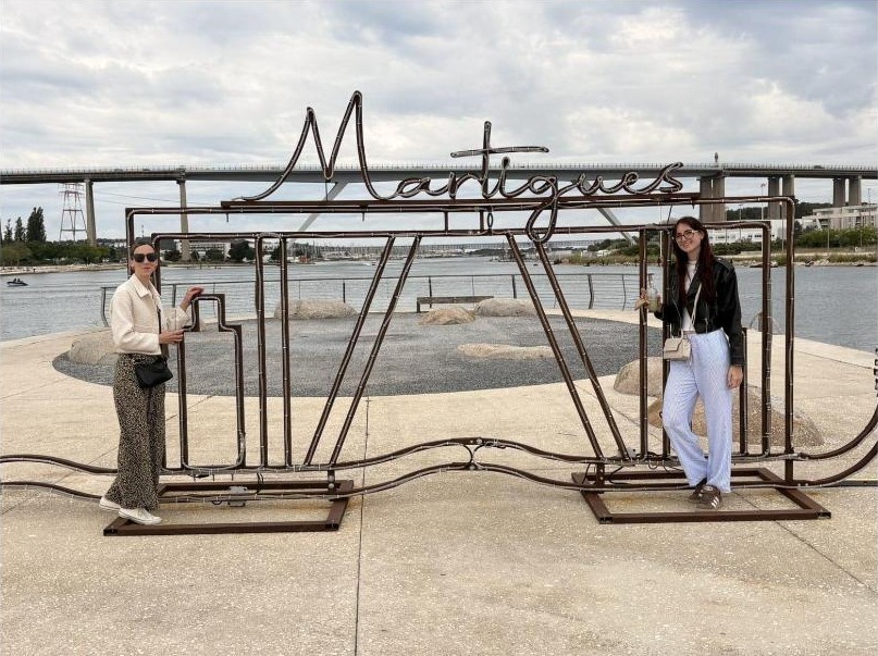 Les deux passagères souriantes devant le panneau Martigues, avant le départ